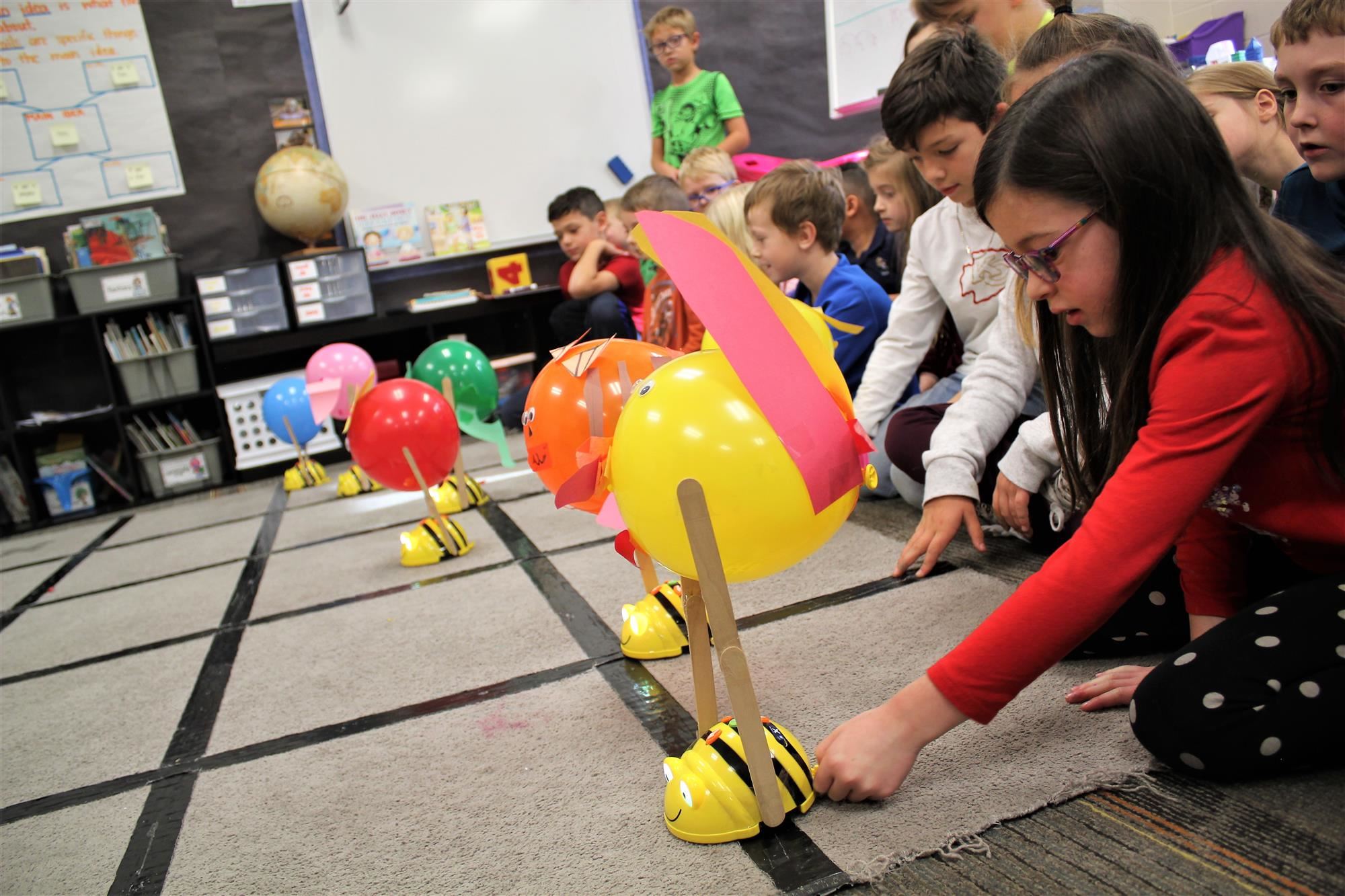 Students using coding skills to maneuver BeeBots 